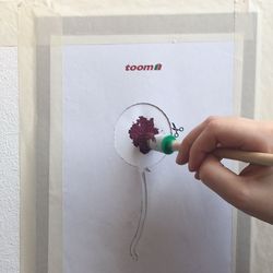 Person malt mit Pinsel auf Papier